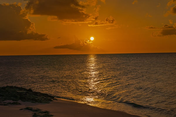 Golden sunset over the Bahamas beach with warm orange sky